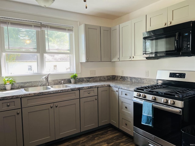 kitchen featuring black microwave, gas stove, gray cabinetry, and a sink
