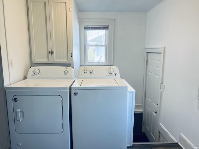 clothes washing area with washer and clothes dryer and cabinet space