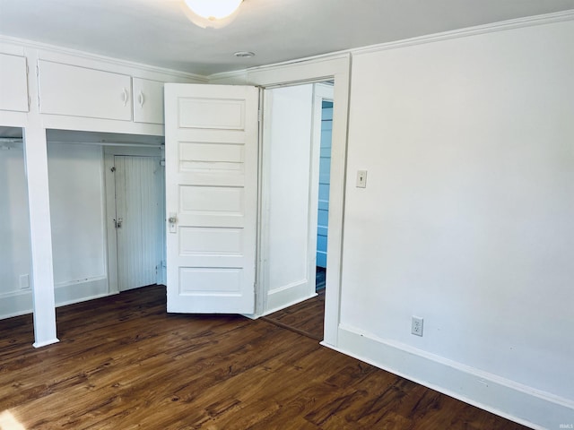 unfurnished bedroom featuring baseboards and dark wood finished floors