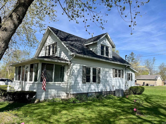 view of side of property featuring a lawn and a sunroom