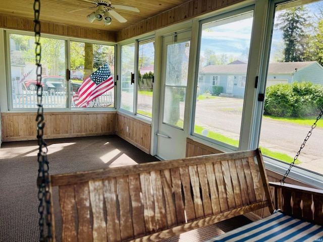 unfurnished sunroom featuring a ceiling fan and a wealth of natural light