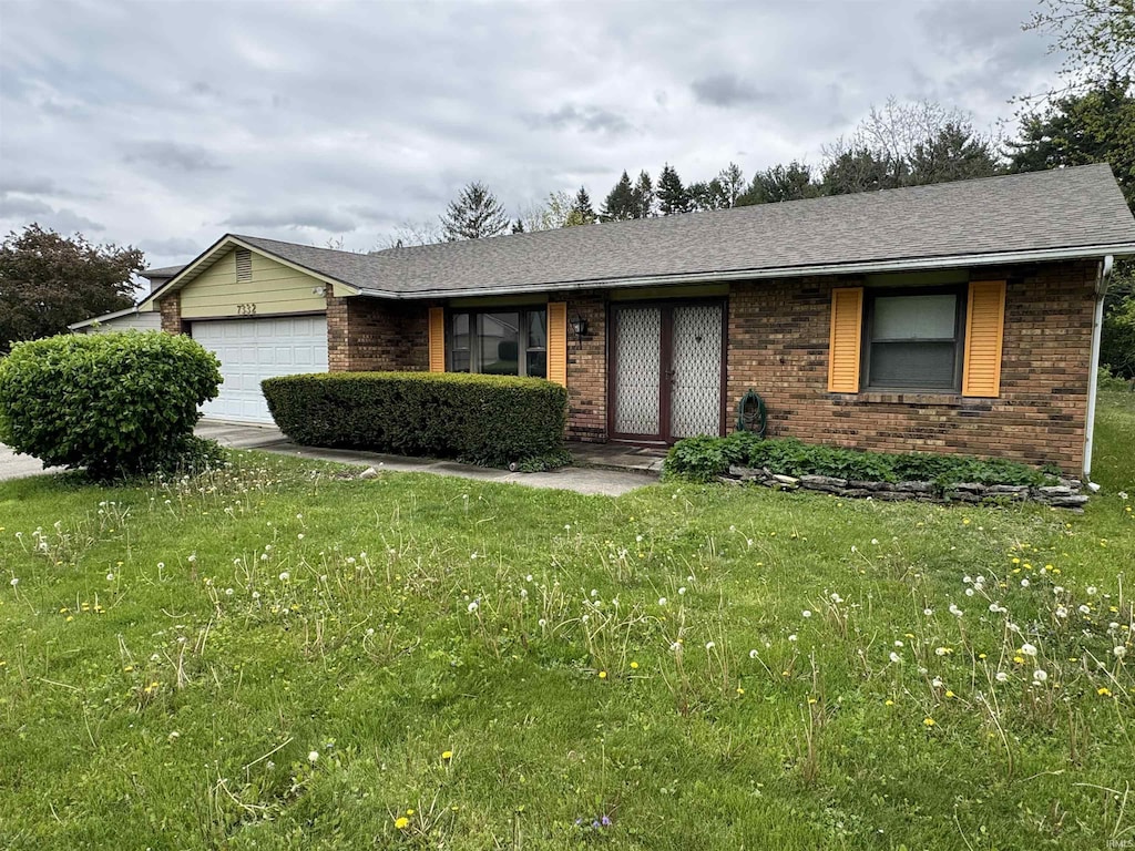 ranch-style house with brick siding, a front lawn, and a garage