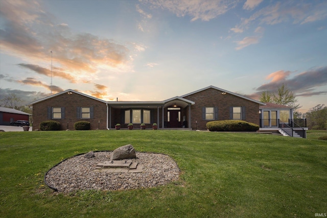 ranch-style home with brick siding and a yard