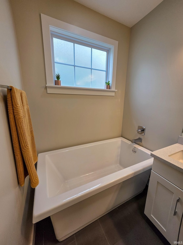bathroom with vanity, a garden tub, and tile patterned floors