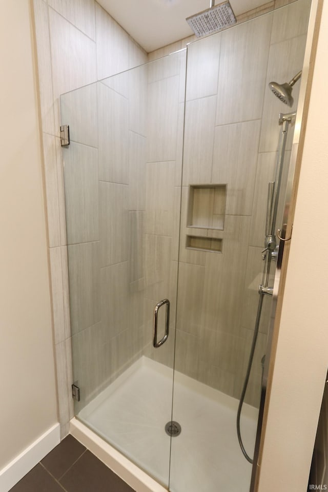 full bathroom featuring baseboards, tile patterned flooring, and a stall shower