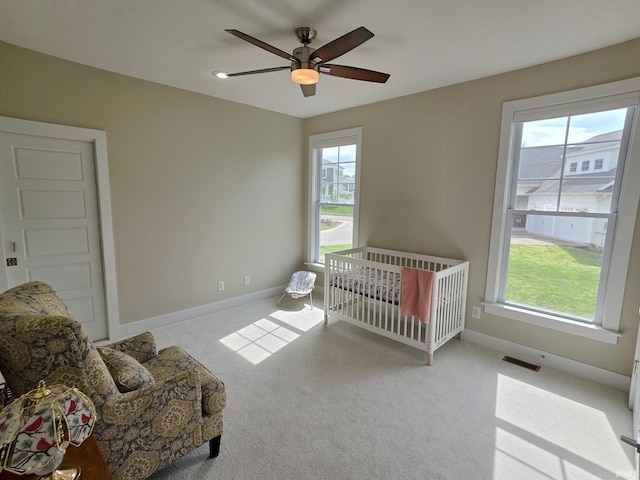 carpeted bedroom featuring a ceiling fan, baseboards, visible vents, and multiple windows
