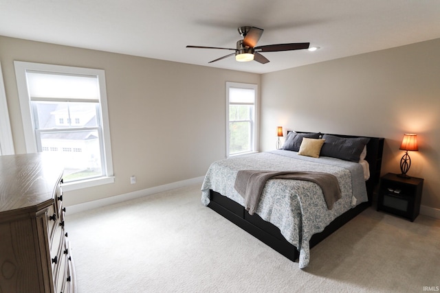 bedroom featuring carpet floors, a ceiling fan, baseboards, and multiple windows