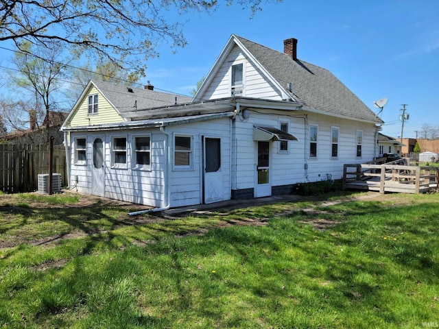 1614 Longley Ave, South Bend, IN 46628 - back of house featuring a chimney, a wooden deck, fence, central AC unit, and a yard