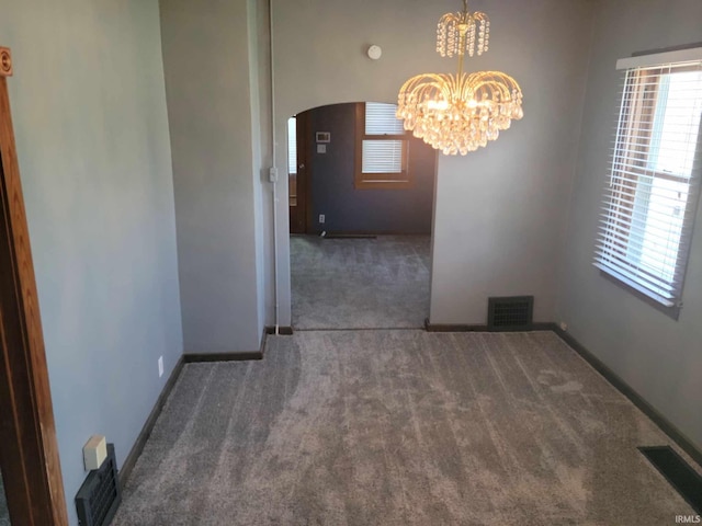 1614 Longley Ave, South Bend, IN 46628 - unfurnished dining area featuring a notable chandelier, carpet floors, visible vents, baseboards, and arched walkways