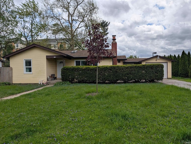 view of front facade with a chimney, fence, driveway, and a front yard
