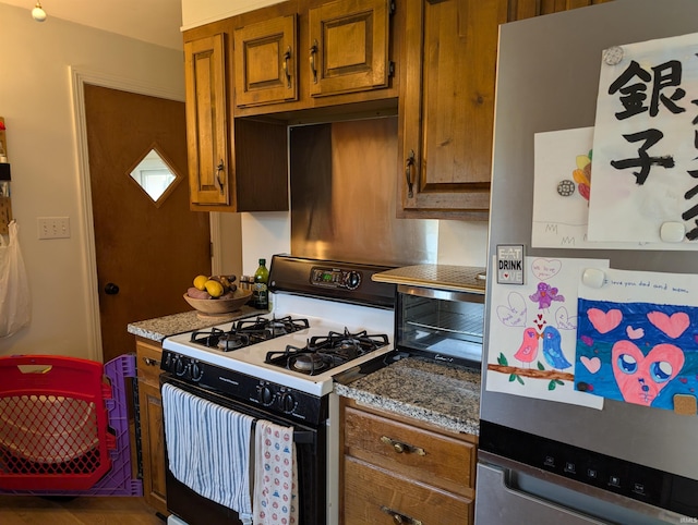 kitchen featuring stone counters, brown cabinets, and white appliances