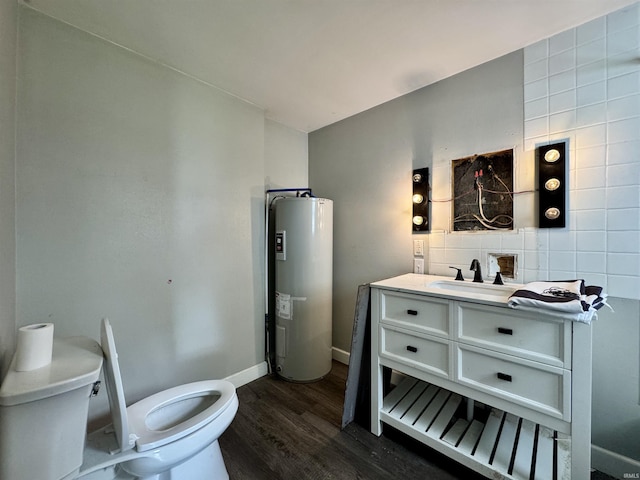 bathroom with vanity, wood finished floors, toilet, baseboards, and water heater