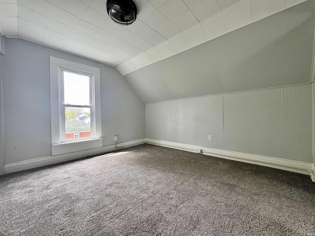 additional living space featuring baseboards, carpet, and vaulted ceiling