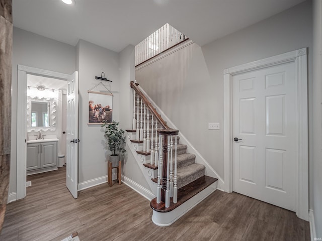 stairway featuring recessed lighting, baseboards, and wood finished floors