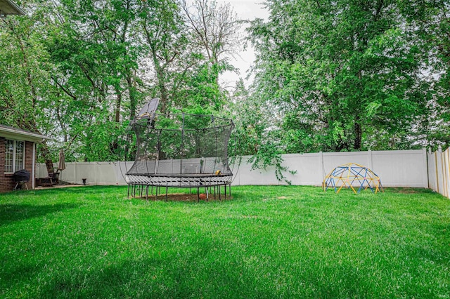 view of yard with a fenced backyard and a trampoline