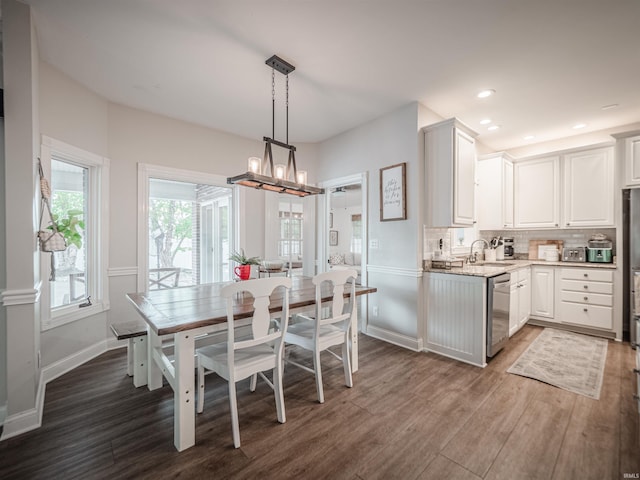kitchen with dishwasher, dark wood finished floors, a chandelier, white cabinetry, and tasteful backsplash