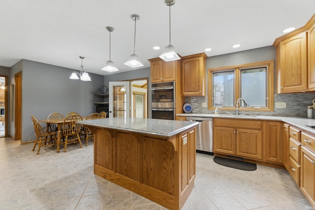 kitchen featuring a sink, appliances with stainless steel finishes, tasteful backsplash, and light stone counters