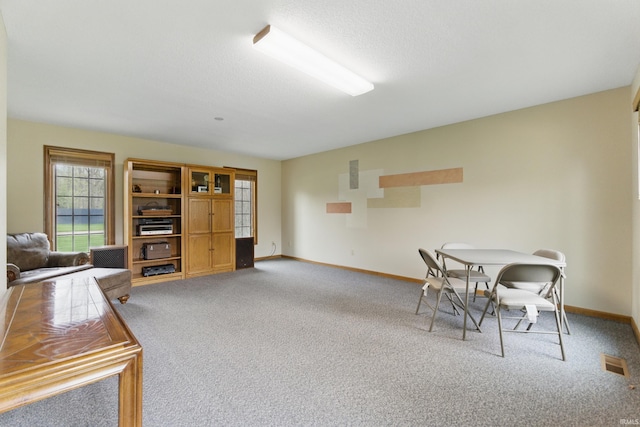 carpeted dining area featuring visible vents and baseboards