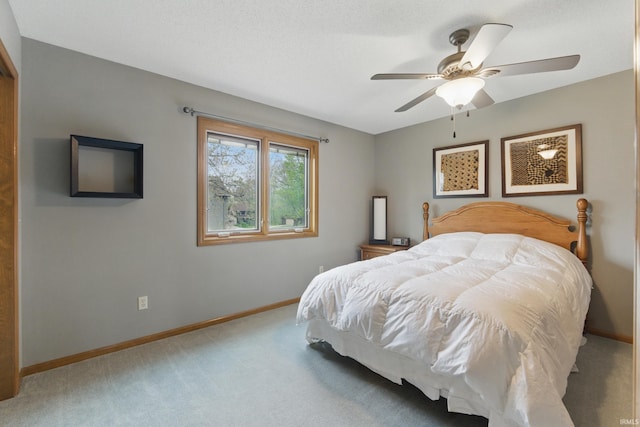 carpeted bedroom with baseboards and a ceiling fan