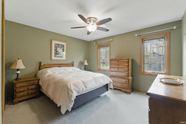bedroom with a ceiling fan, baseboards, and light colored carpet