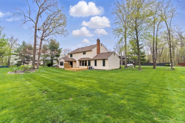 rear view of property featuring a wooden deck, a chimney, a yard, and cooling unit
