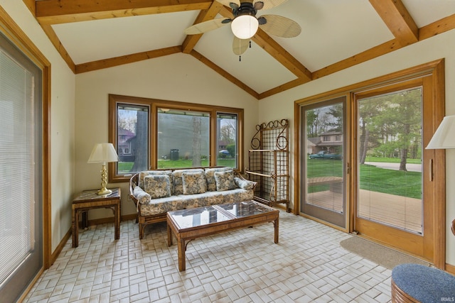 living room with ceiling fan, lofted ceiling with beams, brick patterned floor, and baseboards
