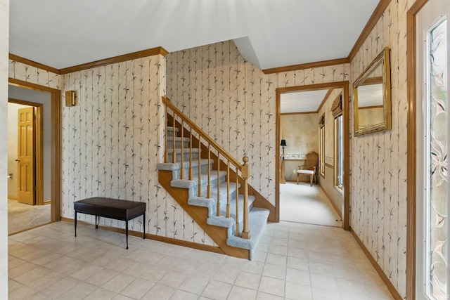 staircase featuring crown molding, baseboards, and wallpapered walls