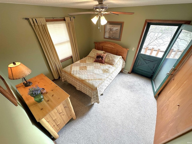 carpeted bedroom with a ceiling fan, baseboards, and access to exterior