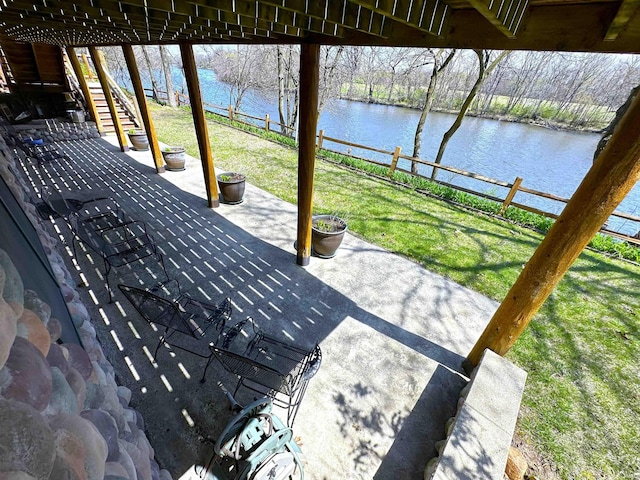 view of patio with a water view, a fenced backyard, and stairway