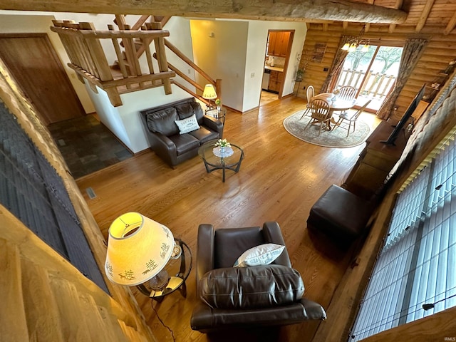 living area with stairway, rustic walls, and wood finished floors