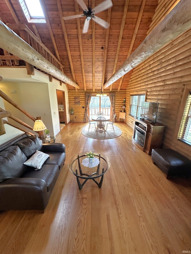 living area with beam ceiling, log walls, wood finished floors, and wood ceiling