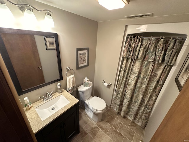 bathroom featuring tile patterned flooring, vanity, toilet, curtained shower, and visible vents