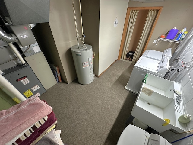 utility room with water heater and washing machine and clothes dryer