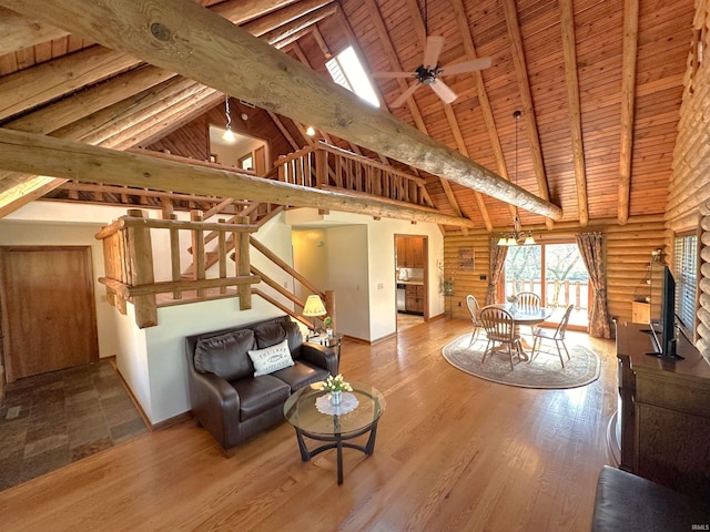 living area featuring stairway, rustic walls, wood ceiling, and high vaulted ceiling