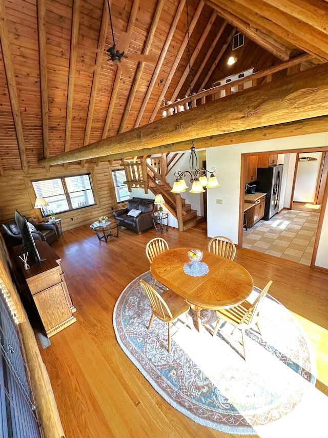 dining area featuring visible vents, an inviting chandelier, beamed ceiling, light wood-style floors, and wood ceiling