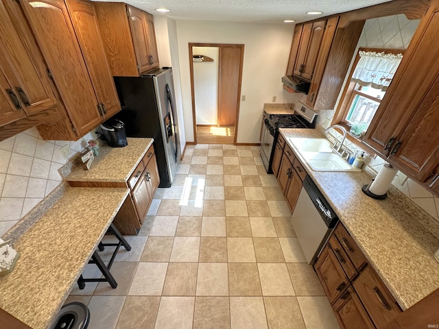 kitchen with a sink, appliances with stainless steel finishes, and brown cabinets