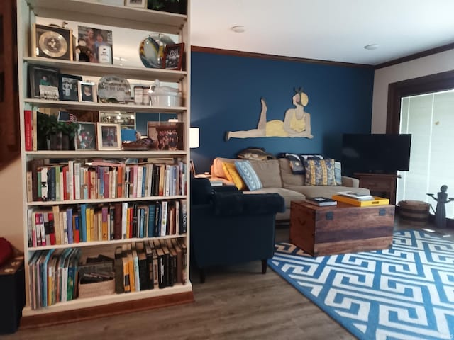 living room with crown molding and wood finished floors