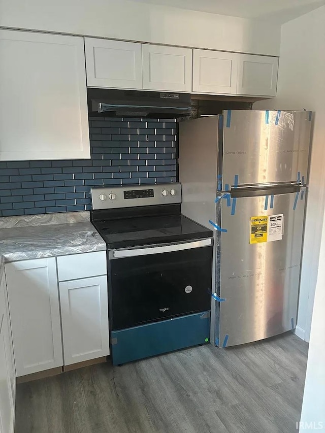 kitchen with under cabinet range hood, stainless steel appliances, white cabinetry, and light wood-type flooring