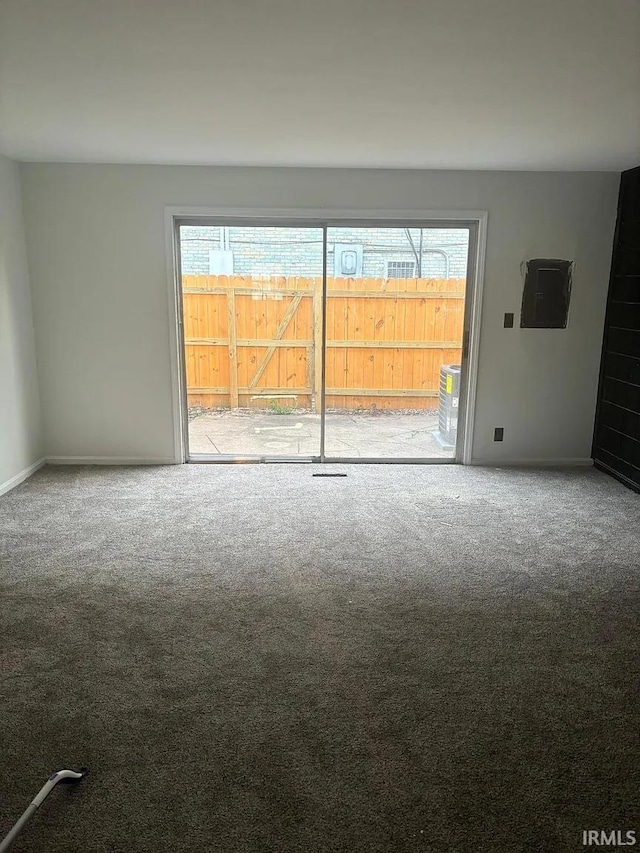 carpeted empty room with baseboards and electric panel