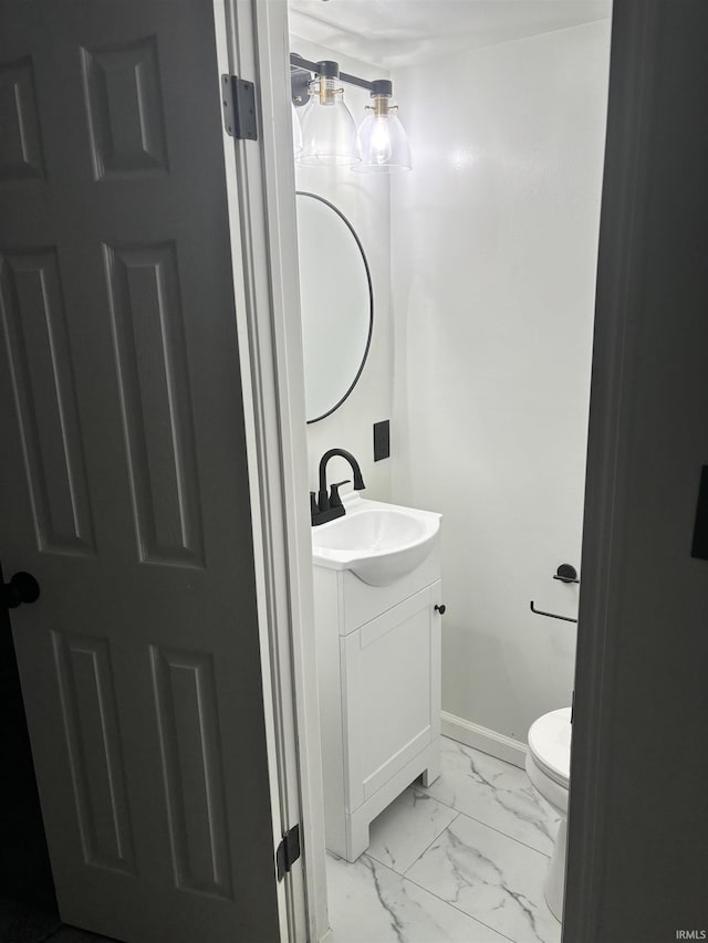 bathroom with vanity, marble finish floor, baseboards, and toilet