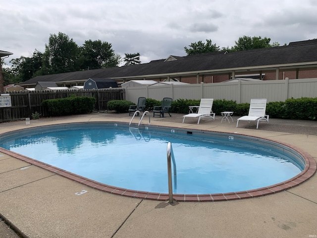 community pool with fence and a patio area