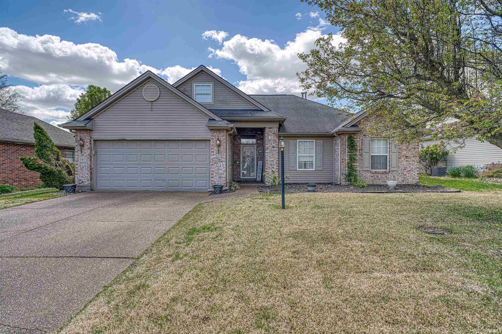 view of front of property with brick siding, a garage, a front lawn, and concrete driveway