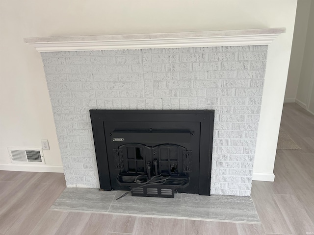 1134 N Iowa St, South Bend, IN 46628 - details featuring visible vents, baseboards, wood finished floors, and a fireplace