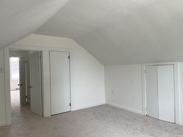 1134 N Iowa St, South Bend, IN 46628 - bonus room featuring baseboards, carpet, a textured ceiling, and lofted ceiling