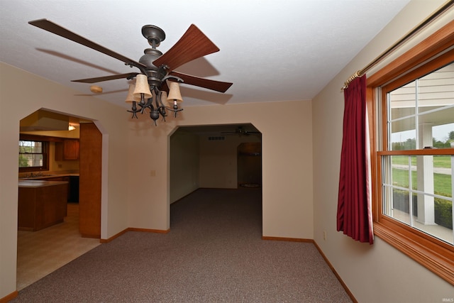 800 E Oak View Est, Winamac, IN 46996 - spare room featuring baseboards, arched walkways, a ceiling fan, and light carpet