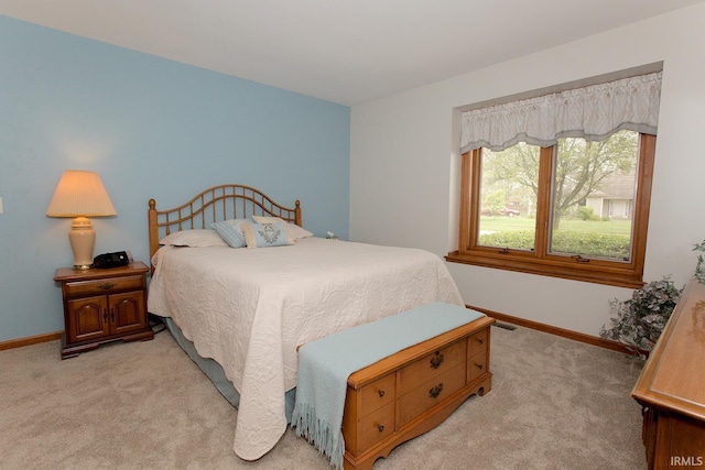 bedroom featuring baseboards, visible vents, and light colored carpet