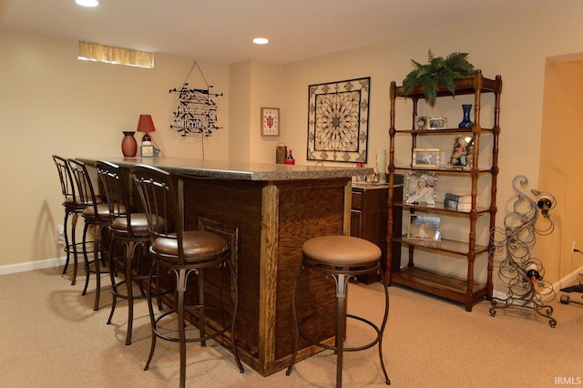 bar with carpet, recessed lighting, and a bar
