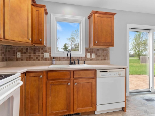 kitchen with visible vents, a sink, white appliances, and light countertops