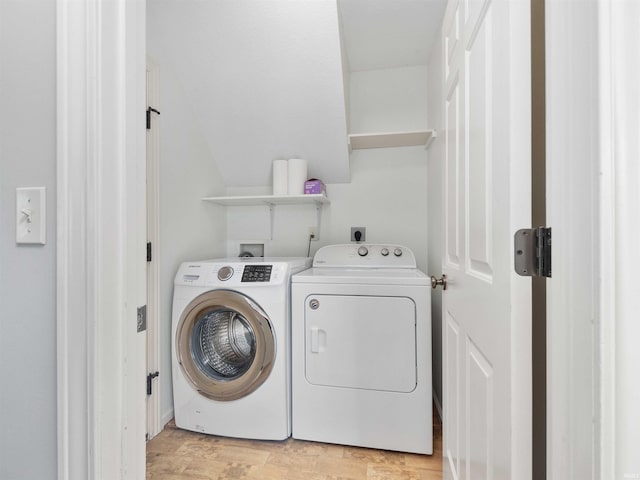 laundry area featuring light wood finished floors and washer and clothes dryer
