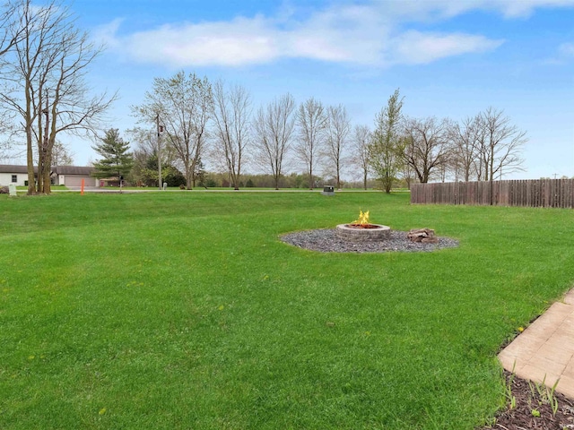 view of yard featuring an outdoor fire pit and fence